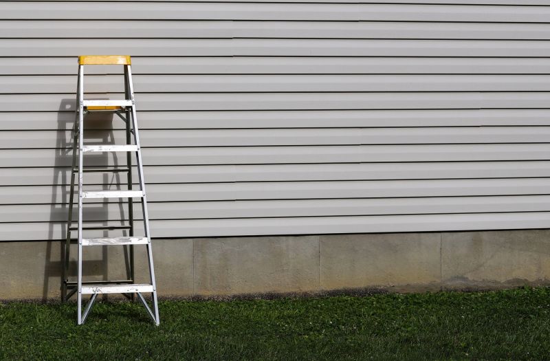 Siding contractor working on a ladder